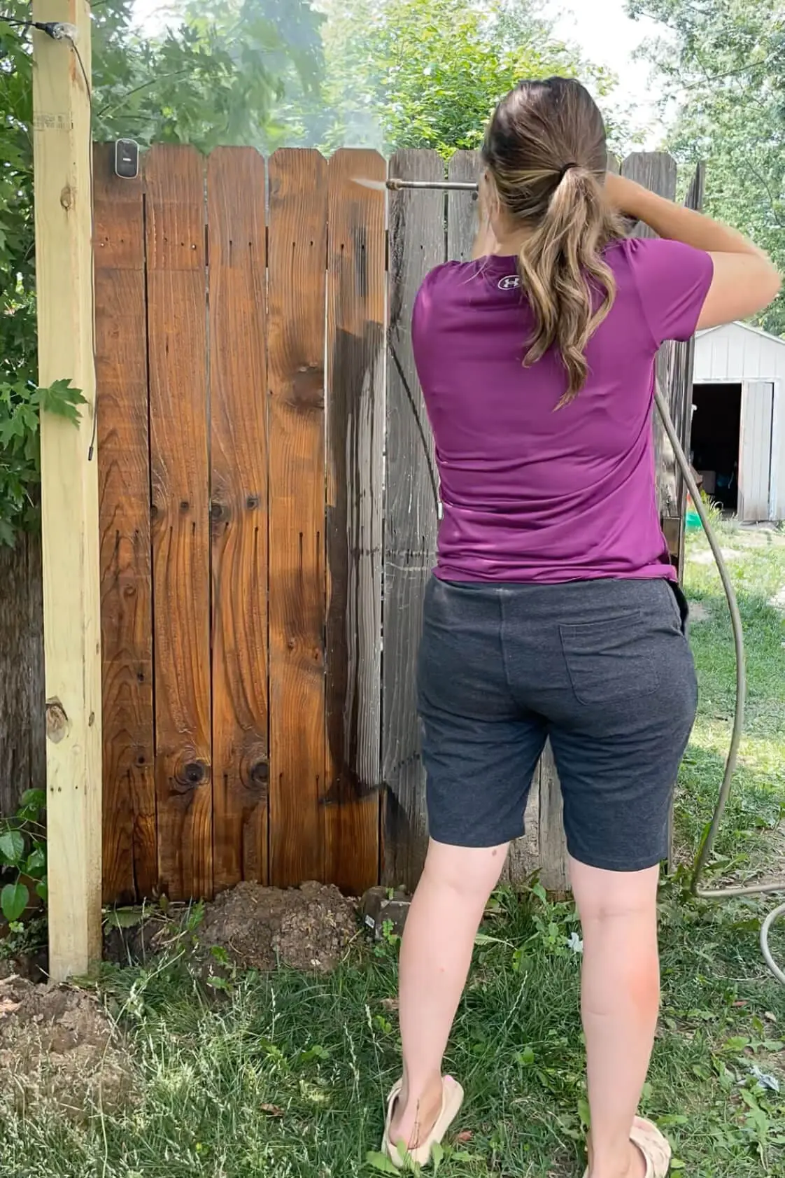 Using a pressure washer on a fence. 